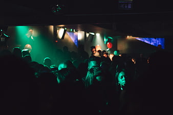 Crowd at a dark nightclub with green stage lighting