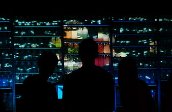 Silhouettes of People in Front of Glowing Blue Jars