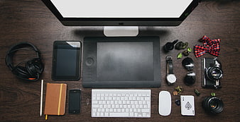 Flat lay of creative workspace with computer, tablet, and accessories
