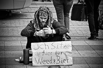 Black and white street photo of homeless man with sign