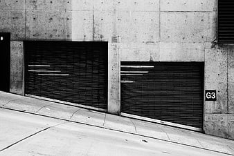 Black and white urban concrete garage doors on a slope