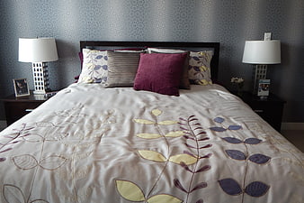 Cozy Bedroom Interior With Floral Bedding And Patterned Wallpaper