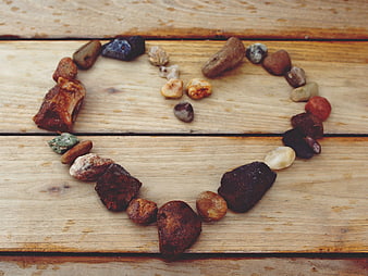 Heart Shape Formed By Natural Stones On Rustic Wooden Planks