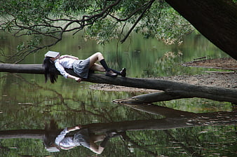 Woman Sleeping on Fallen Log in Forest with Reflection