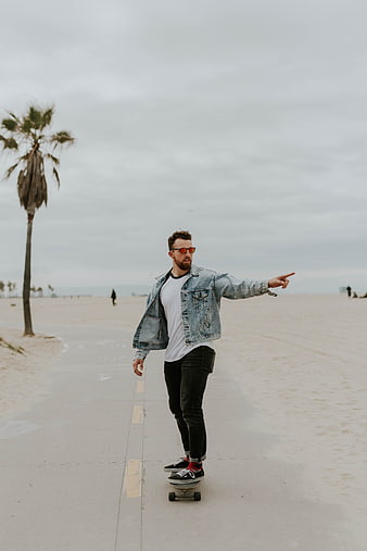 Man Skateboarding on Beach Boardwalk with Palm Tree
