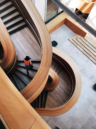 High angle view of woman on modern curved wooden staircase
