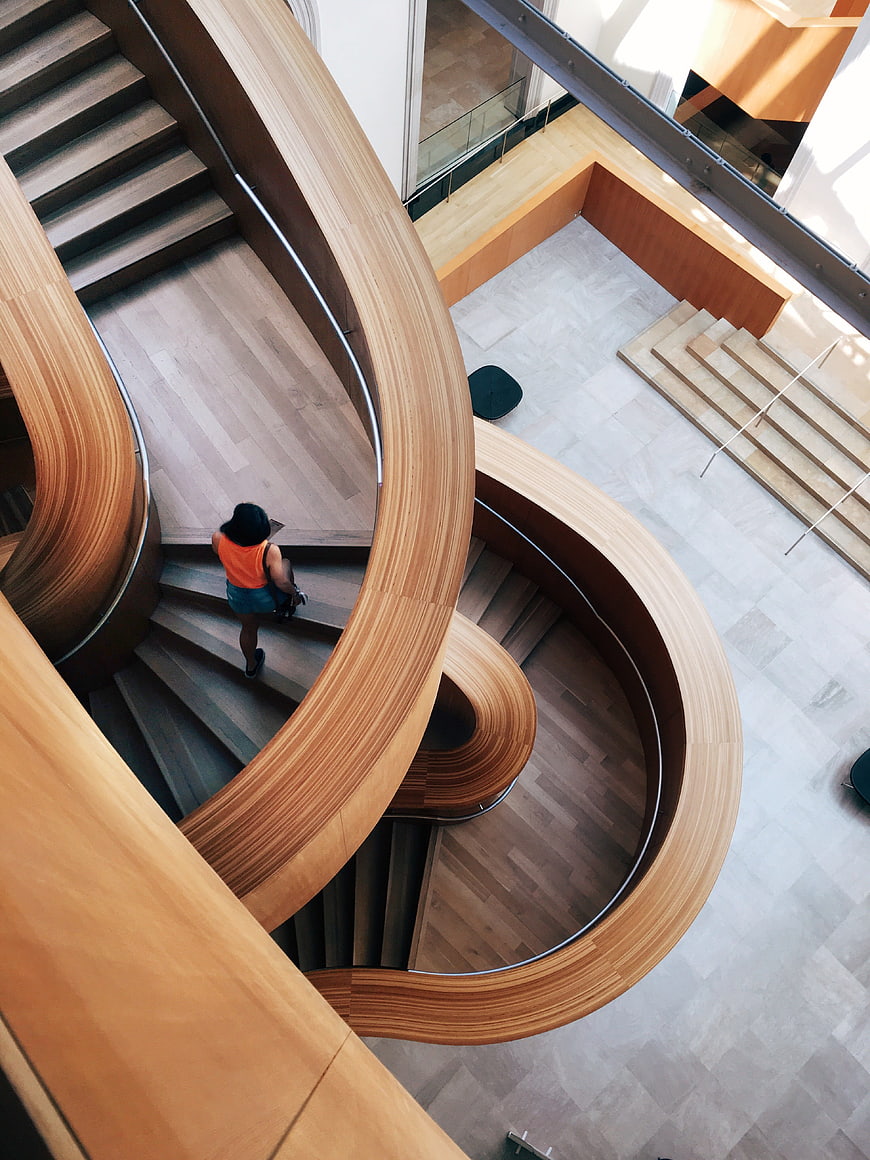 High angle view of woman on modern curved wooden staircase