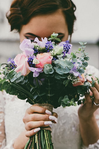 Bride holding colorful bouquet with pink roses and eucalyptus