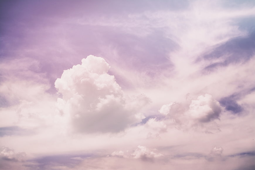 Dreamy purple and pink sky with fluffy white cumulus clouds