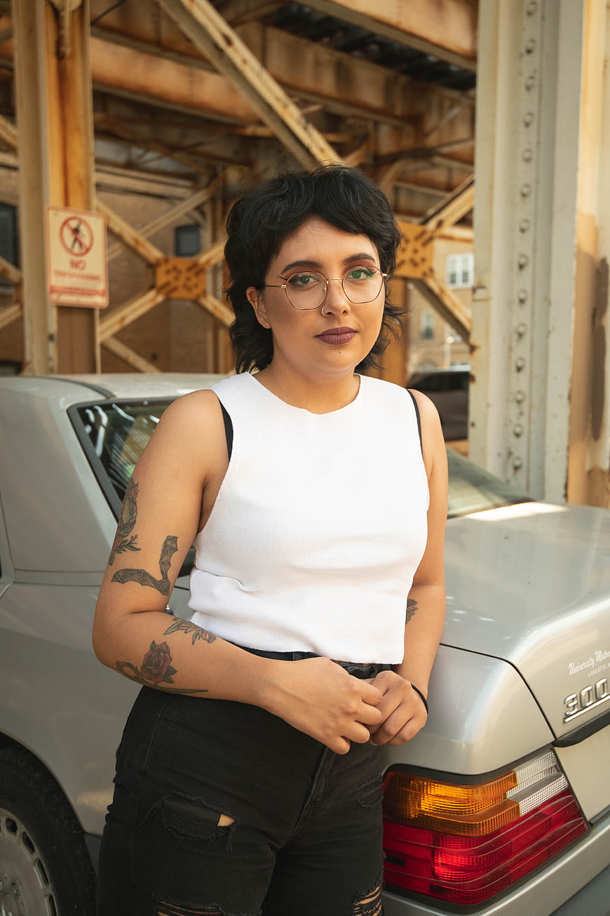 Confident Tattooed Woman Portrait by Vintage Car