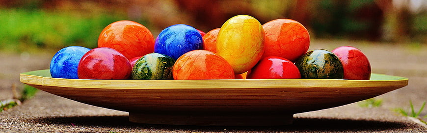 Colorful Easter Eggs in Wooden Bowl on Outdoor Table