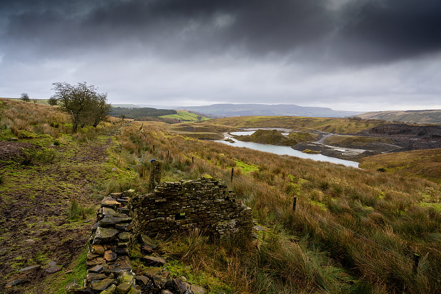 Dramatic moody landscape with stone ruins and river valley
