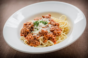 Spaghetti Bolognese with Parmesan and Parsley on White Plate