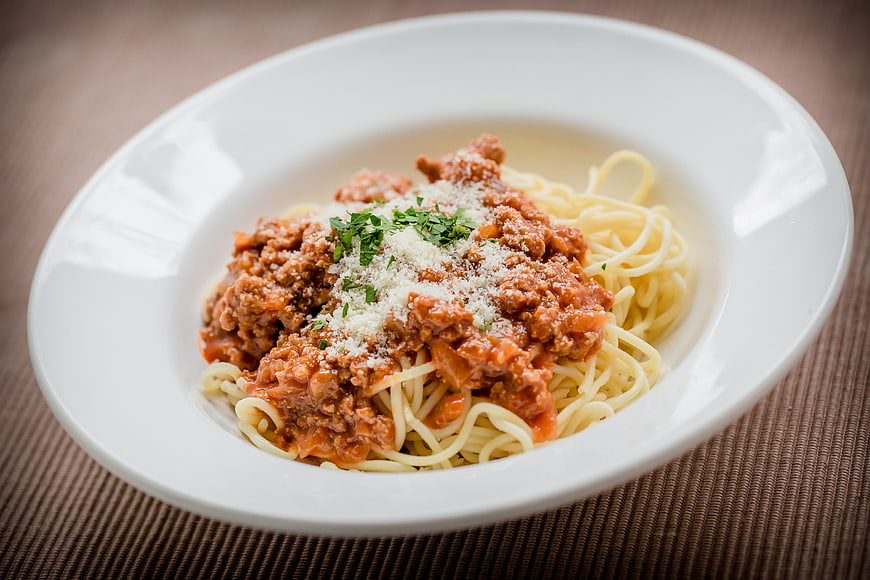 Spaghetti Bolognese with Parmesan and Parsley on White Plate