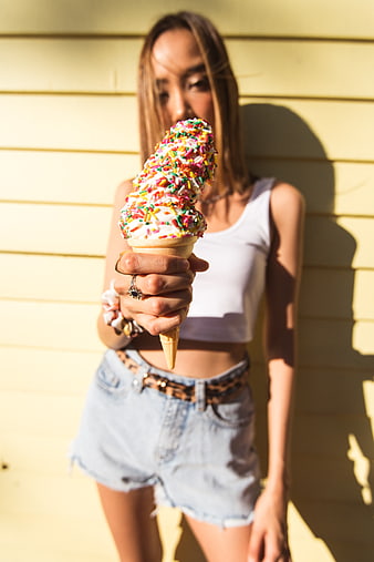 Woman Holding Sprinkled Ice Cream Cone in Sunlight