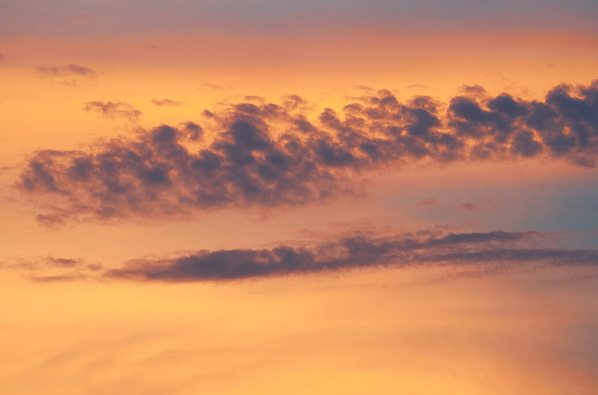 Vibrant orange and purple sunset cloudscape sky background