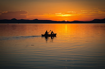 Silhouette of Two People Kayaking on Lake at Sunset