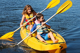 Woman and Boy Paddling Yellow Kayak on Blue Water