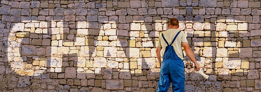 Painter projecting choice word on stone wall