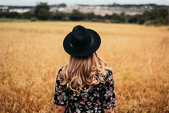 Woman in Black Hat Standing in Golden Wheat Field