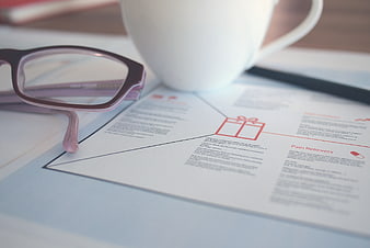 Pink Glasses and Coffee Mug on Business Documents