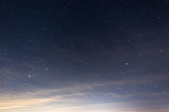 Starry Night Sky with Faint Horizon Glow and Wispy Clouds