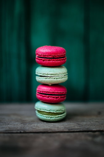 Stack of pink and green macarons on wooden table