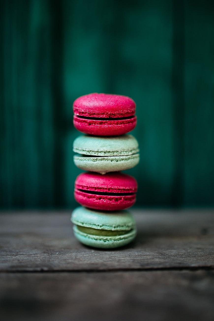 Stack of pink and green macarons on wooden table