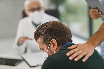 Doctor comforting patient during medical consultation