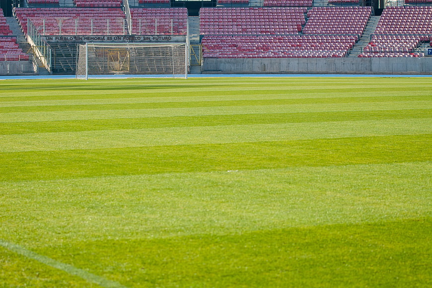 Empty Soccer Stadium with Striped Green Grass Field