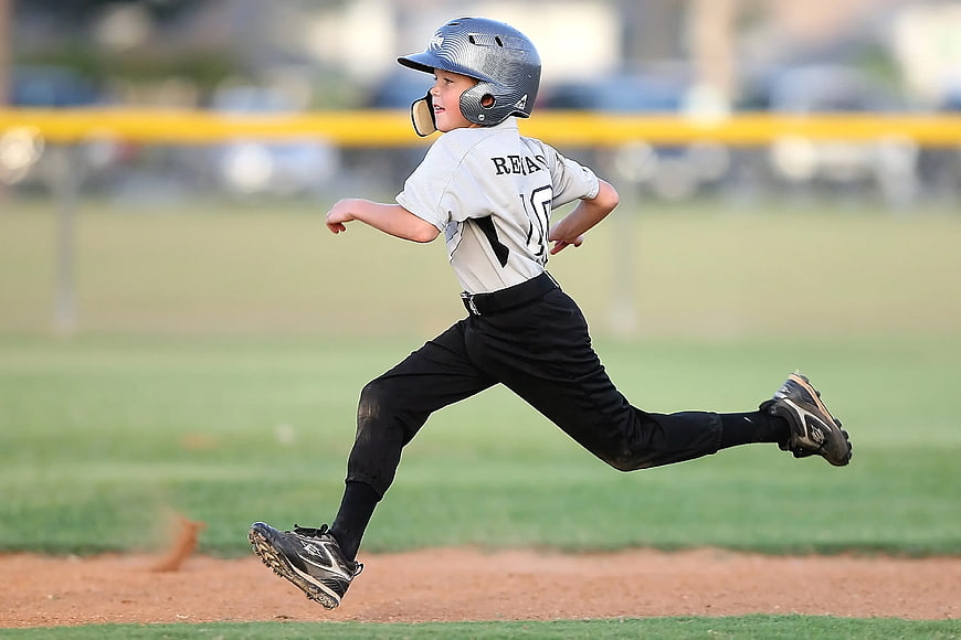 Young Baseball Player Running on Dirt Field