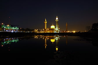 Night view of illuminated mosque with reflection in water