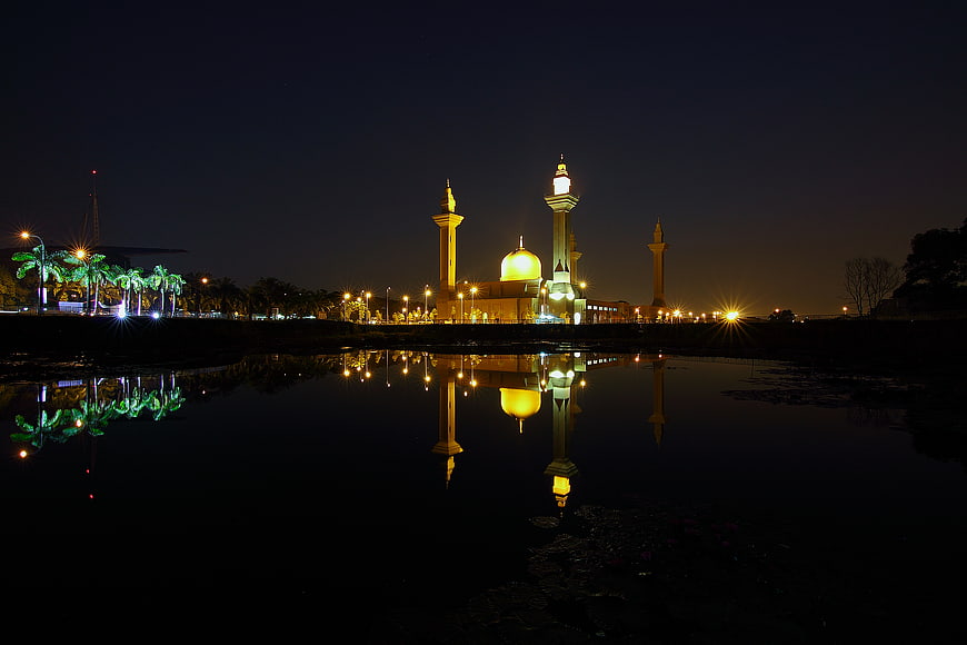 Night view of illuminated mosque with reflection in water