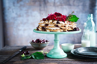 Rustic layered cake with cherries and flowers on mint stand