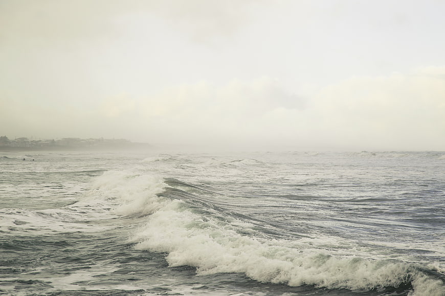 Foggy ocean waves crashing on a misty overcast day