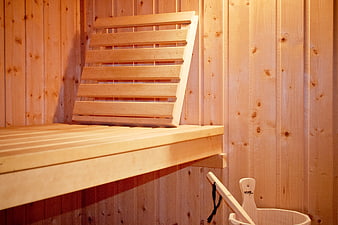 Cozy wooden sauna interior with bench and bucket