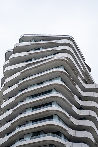 Low angle view of modern white wavy apartment building