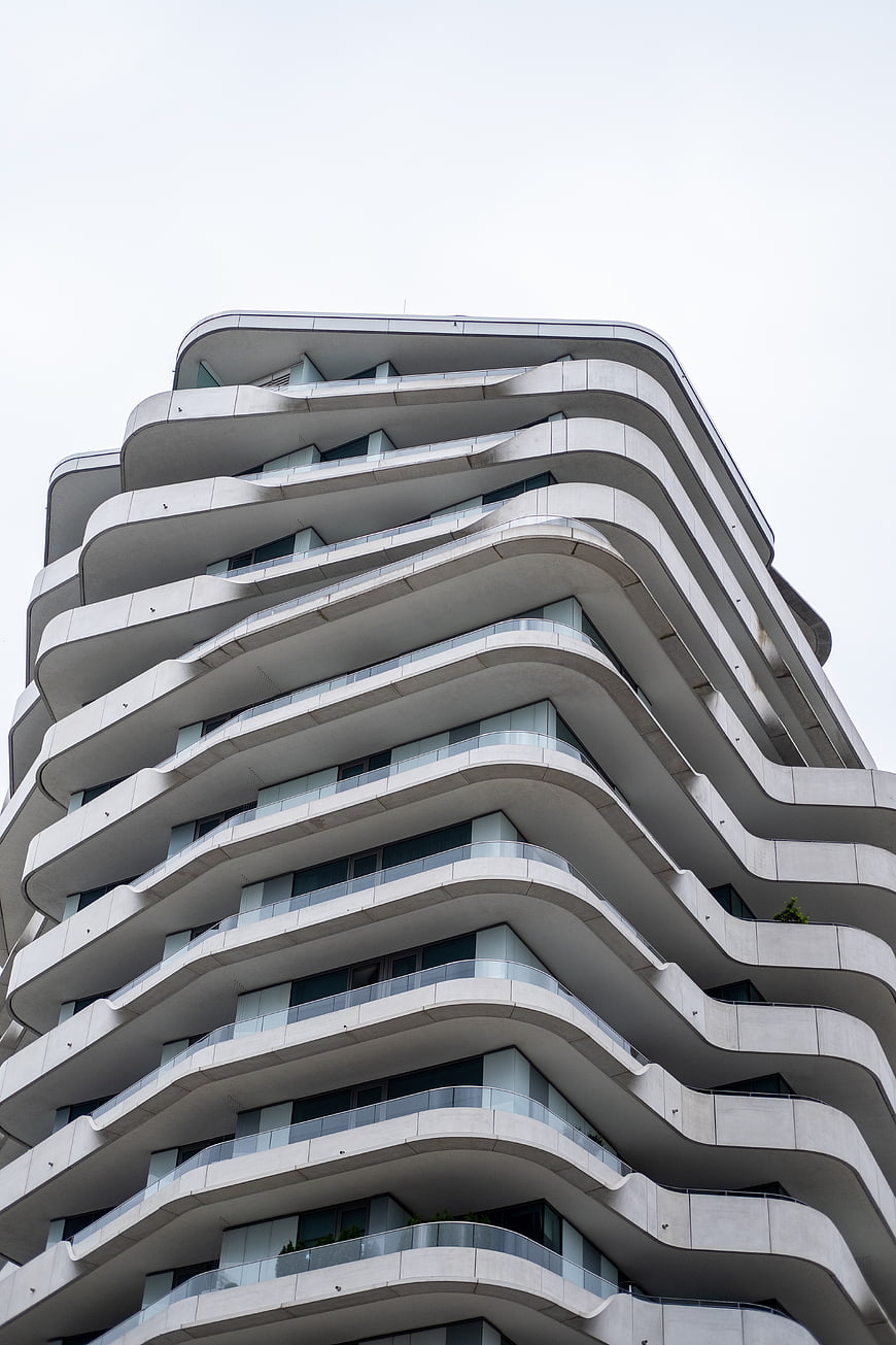 Low angle view of modern white wavy apartment building