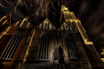 Dramatic HDR Night View of Historic Brick Church with Statue