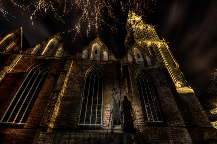 Dramatic HDR Night View of Historic Brick Church with Statue