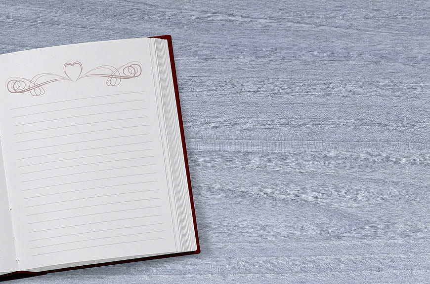 Open lined notebook with heart design on gray wood background