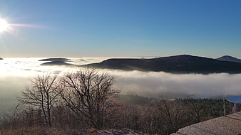 Sunrise over mountain peaks above sea of clouds