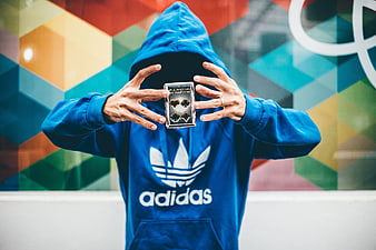 Anonymous man in blue hoodie holding playing cards