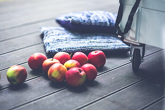 Red apples on wooden deck with blue pillows