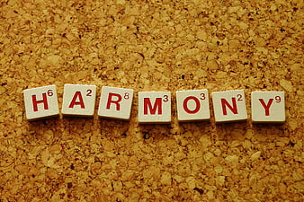 Scrabble tiles spelling the word harmony on a textured cork background