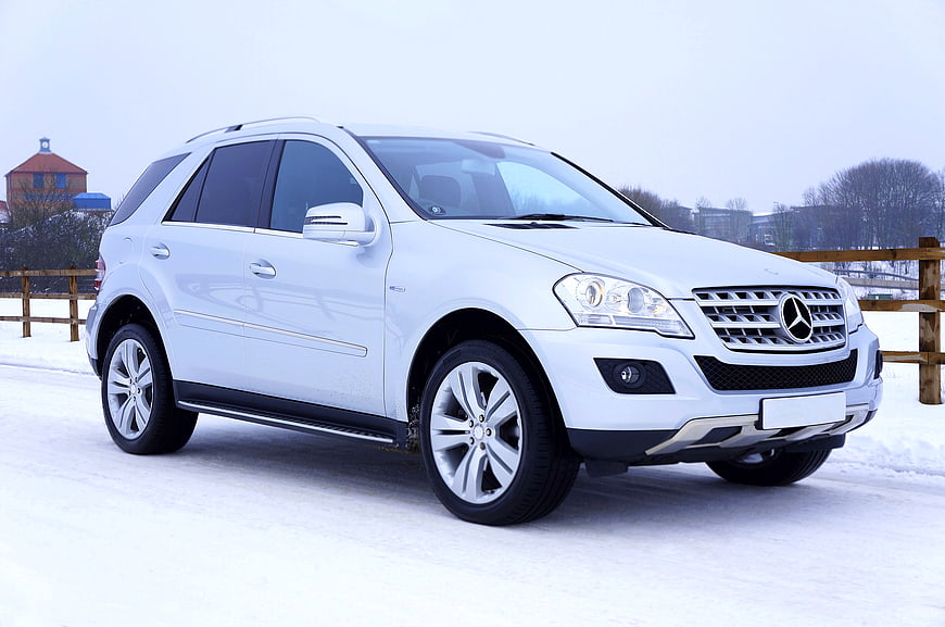 White Mercedes-Benz SUV parked on snowy road
