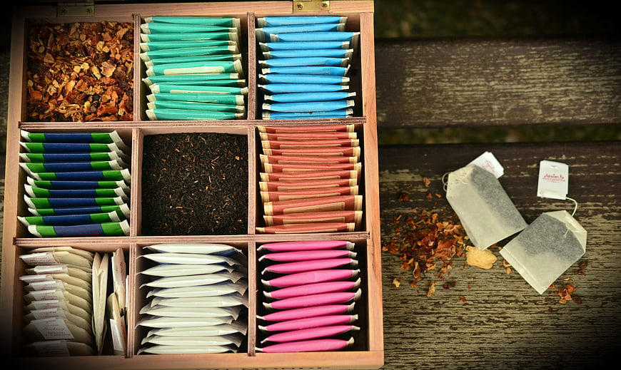 Wooden tea box with colorful sachets and loose leaf tea