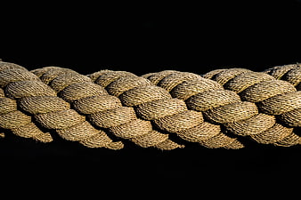 Close-up of thick twisted rope texture on black background