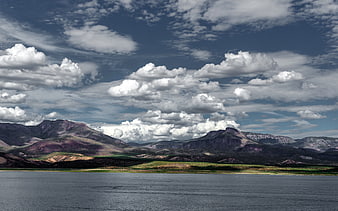 Dramatic mountain landscape with lake and cloudy sky