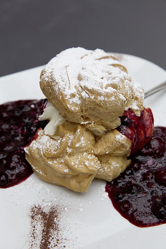 Puffed pastry dessert with berry sauce and powdered sugar